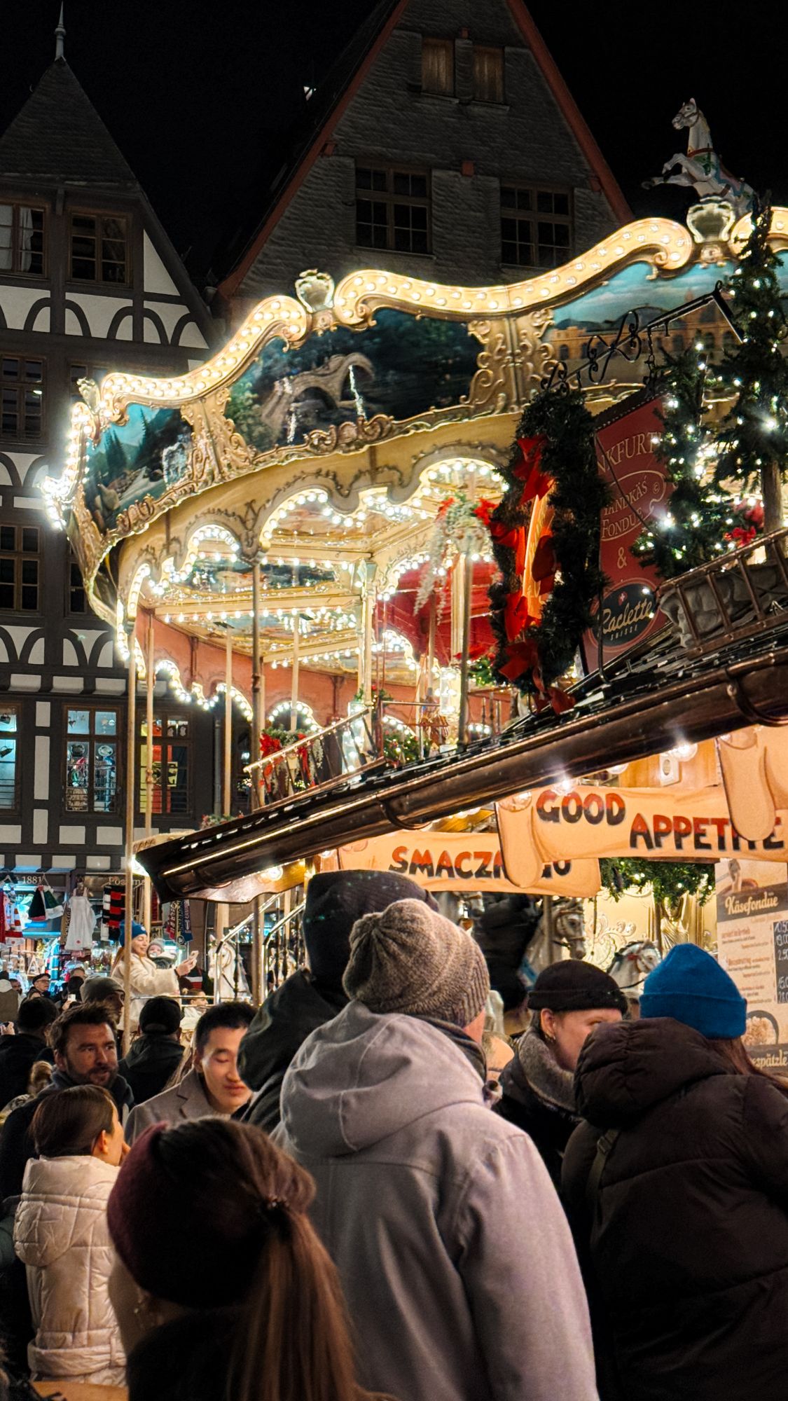 Beleuchtetes Karussell vor Fachwerkhäusern auf dem Frankfurter Weihnachtsmarkt am Römerberg